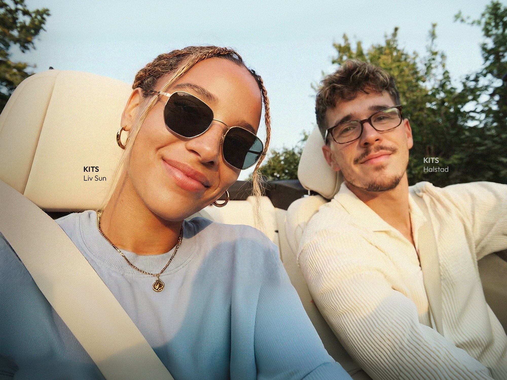 Two people wearing KITS summer eyewear in a car